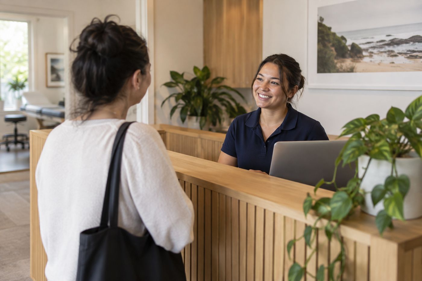 A receptionist greeting a client at a calm clinic front desk
